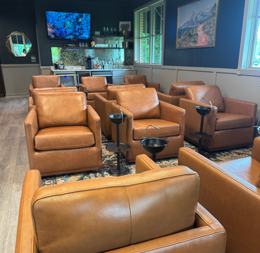 The main lounge at Chartwell: tan leather club chairs, ashtray stands and a bar under low light