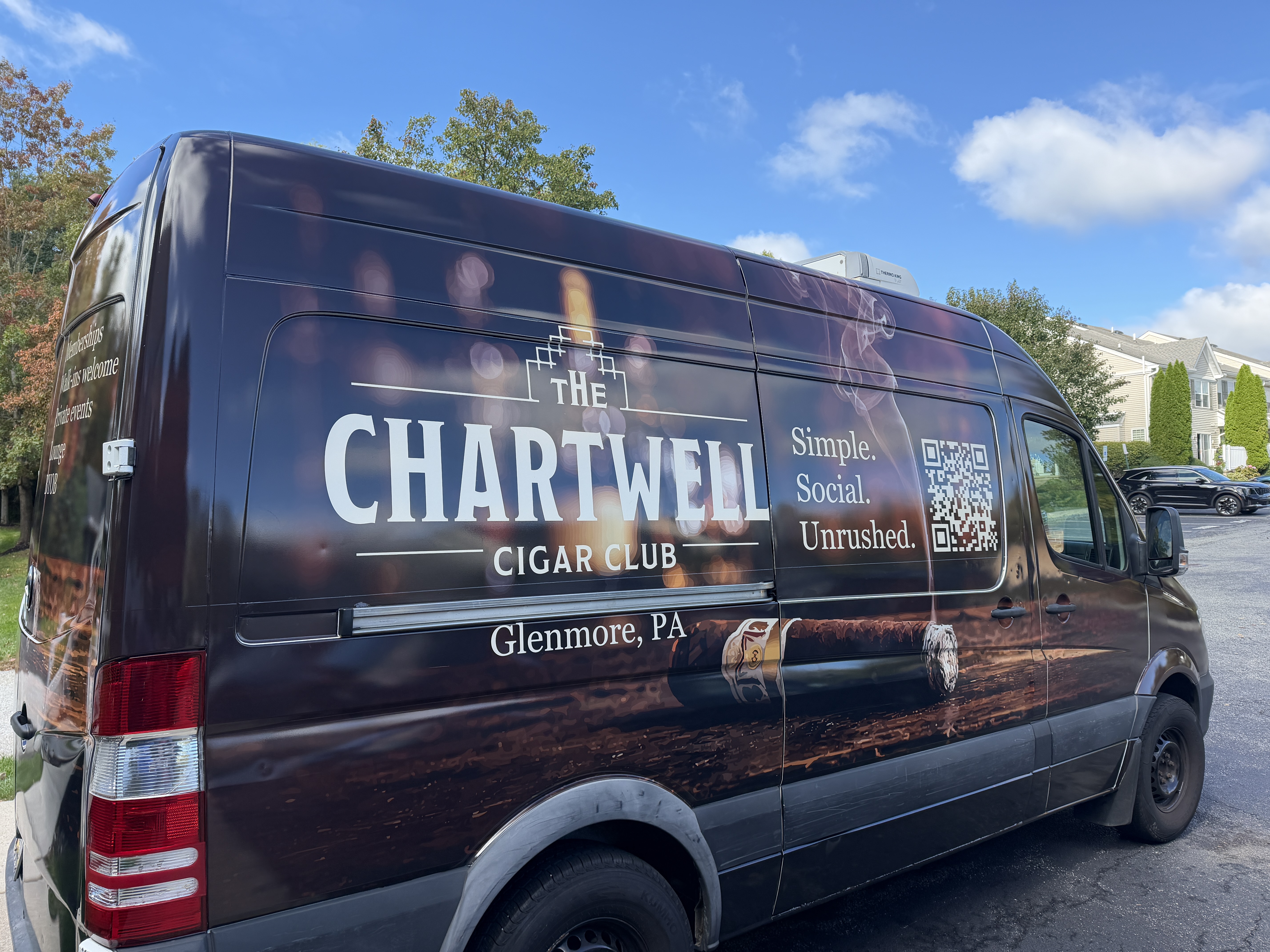 The Chartwell Cigar Club truck, a dark brown wrapped van with the club logo and tagline